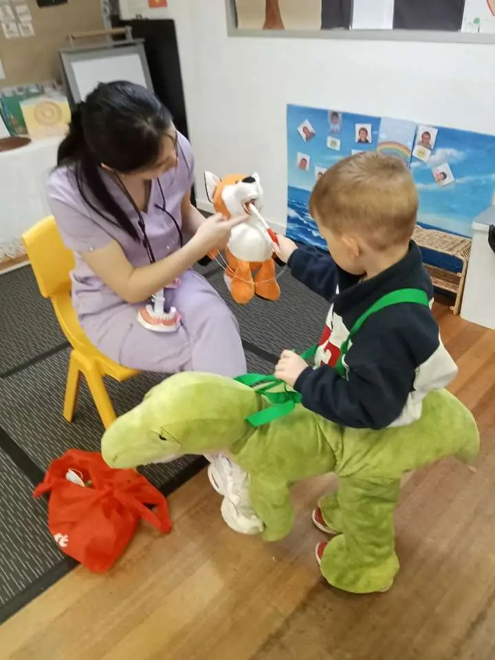 Qualified early childhood educator with child at Kindoo